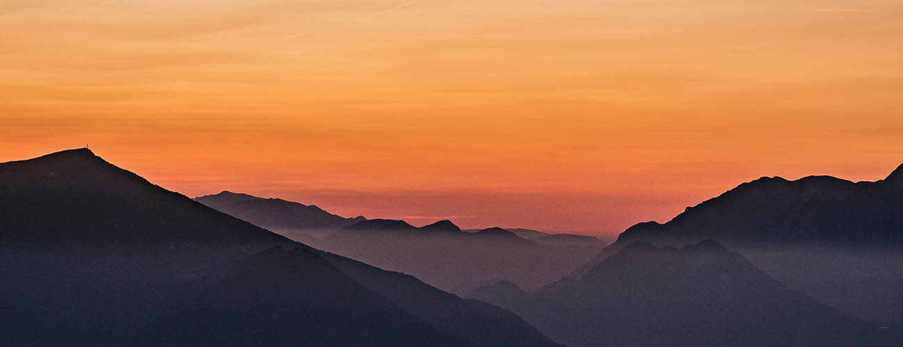 ciel orange et sommet de montagnes bleu sombre