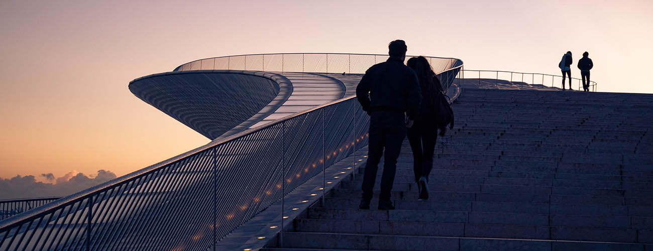 couple se baladant sur un point de vu d'une structure moderne en fin de journée 