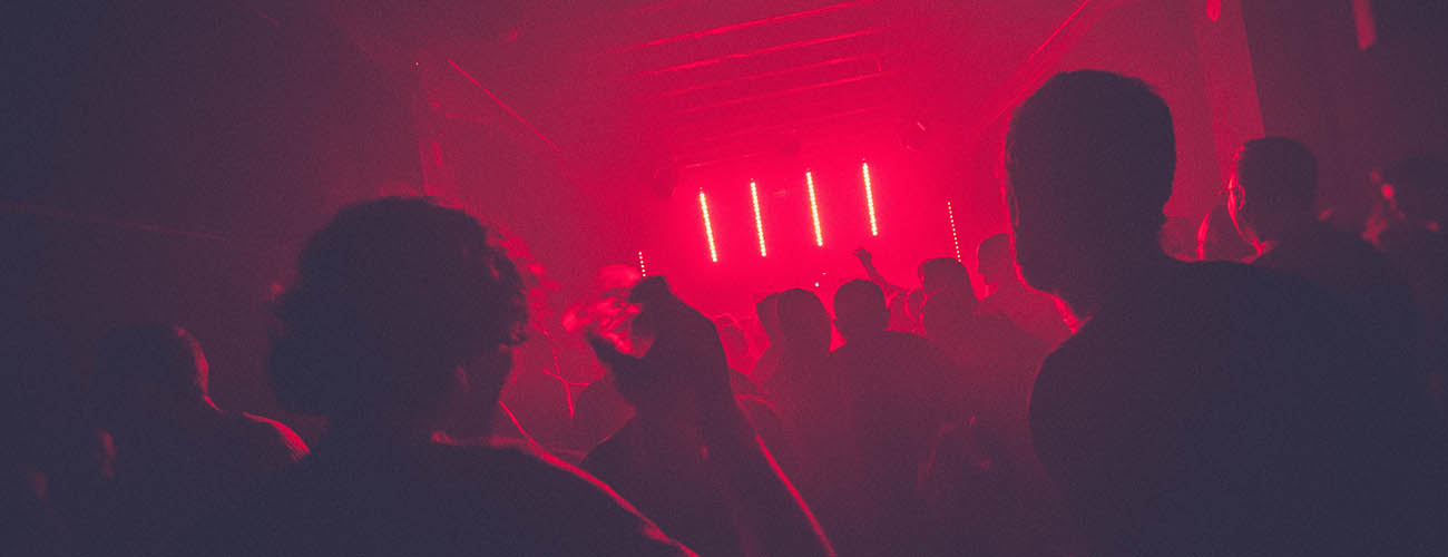 foule dansant en boite de nuit, projecteurs rouge